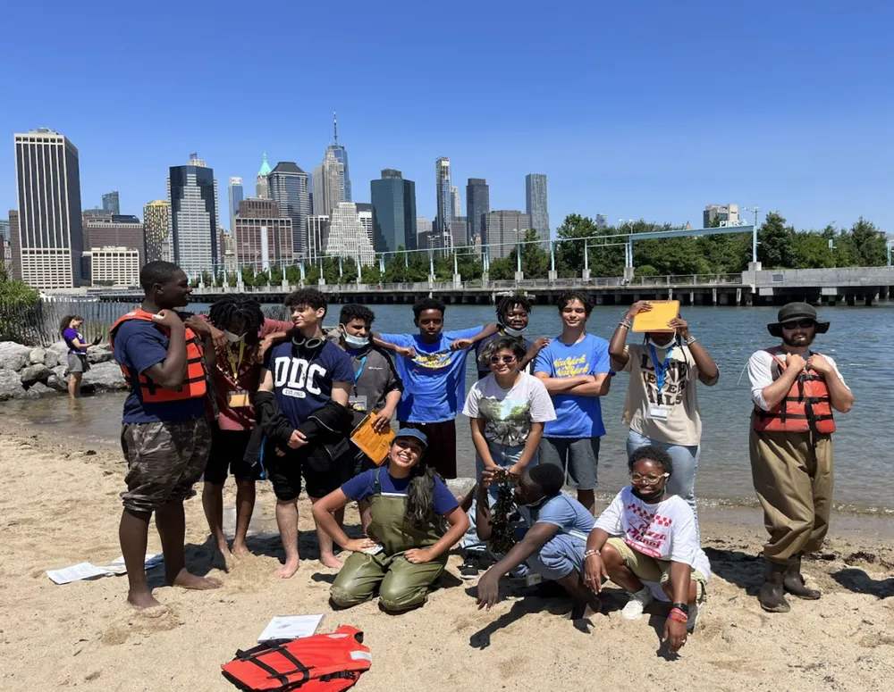 Student group poses for photo in front of river