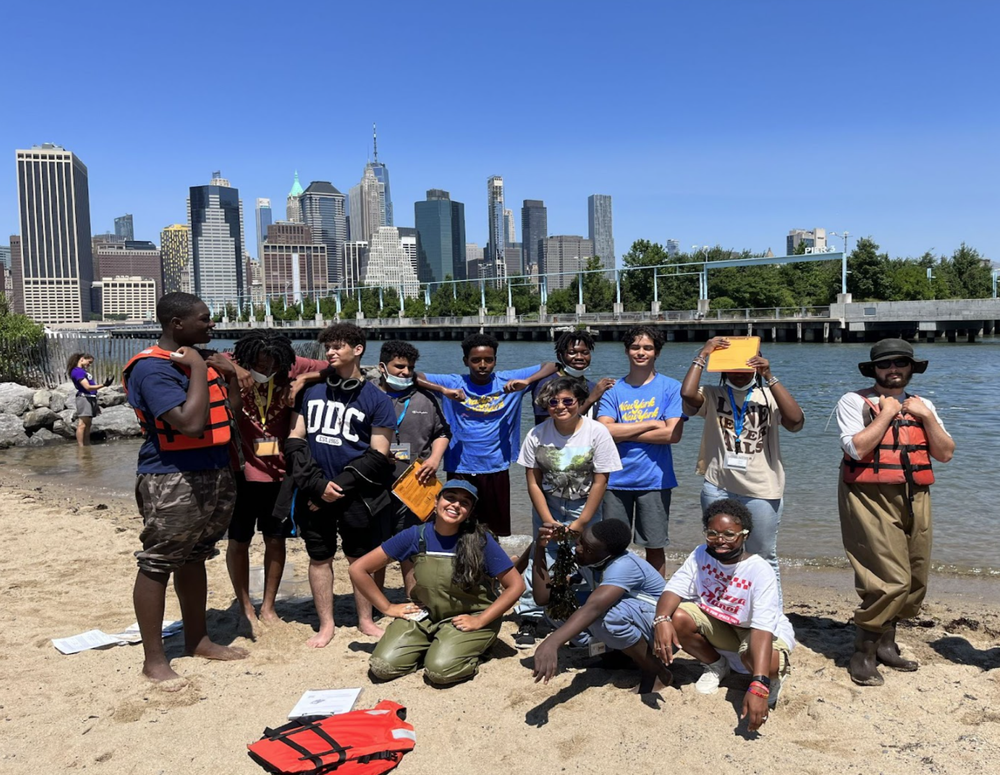 Student group poses for photo in front of river